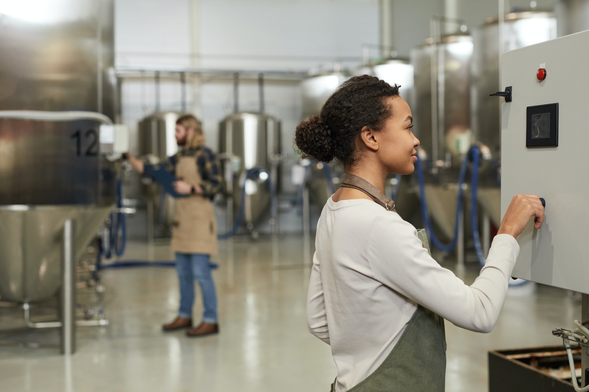 Young Woman Starting Machines at Brewery